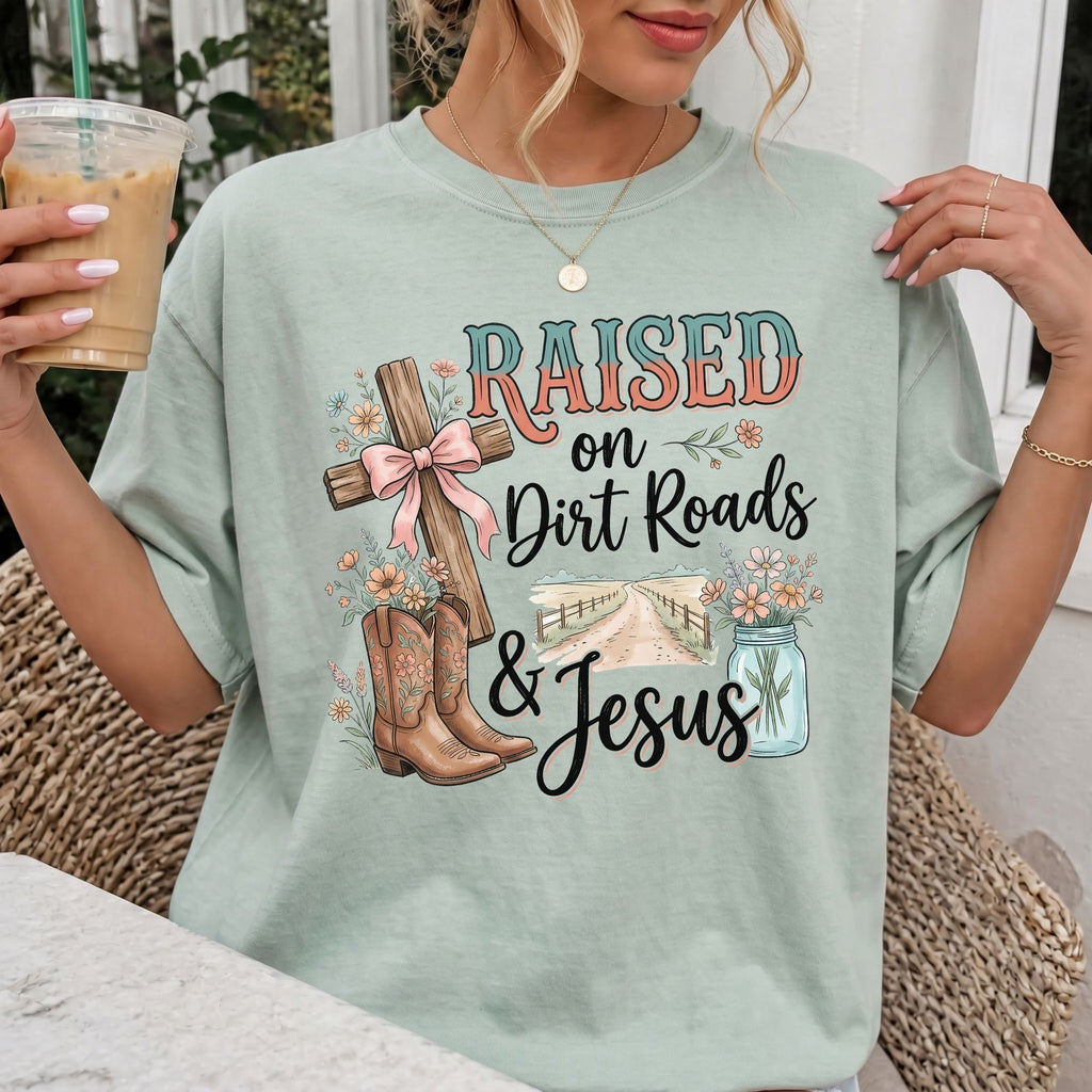 Woman wearing Raised on Dirt Roads & Jesus Christian Comfort Colors T-Shirt in Bay