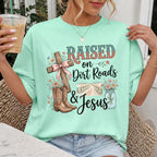 Woman wearing Raised on Dirt Roads & Jesus Christian Comfort Colors T-Shirt in Island Reef
