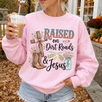 Woman wearing Raised on Dirt Roads & Jesus Christian sweatshirt in Light Pink